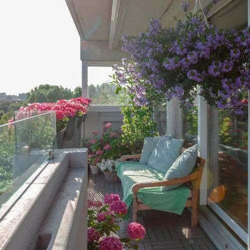 Balkon mit Hängeblumen und Sitzbank
