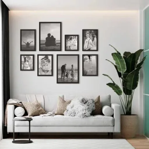 Bilderwand mit schwarzen Rahmen über dem Sofa
