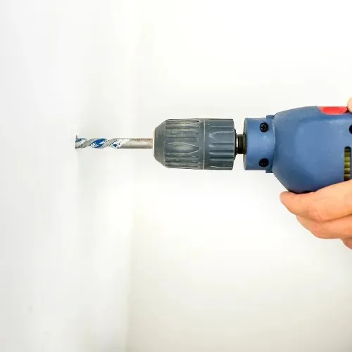 Bohrmaschine an einer weißen Wand