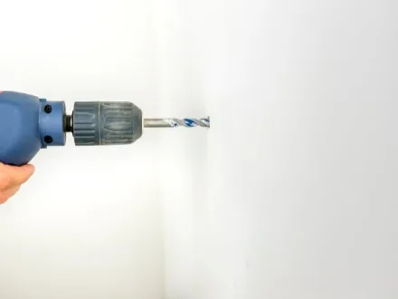Bohrmaschine an einer weißen Wand