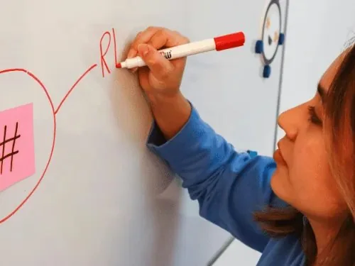 Frau schreibt auf ein Whiteboard