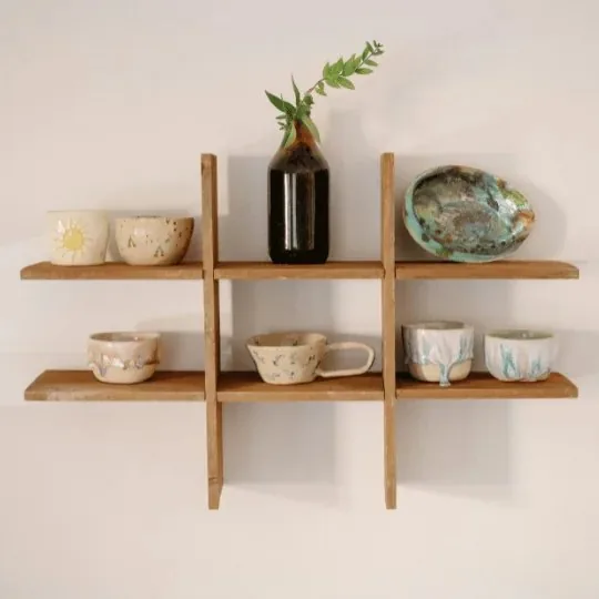 Holzregal mit Tassen an der Wand