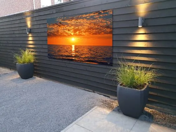 Großes Outdoor-Bild an einem dunklen Holzzaun im Garten