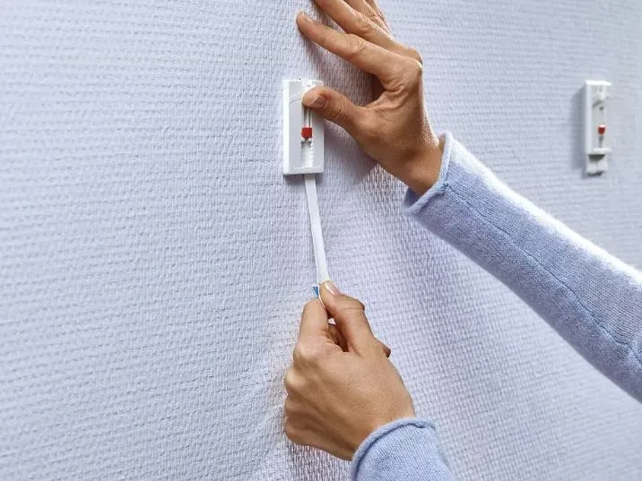 Klebenagel entfernen: Tesa Klebenagel über die Lasche flach nach unten von der Wand lösen